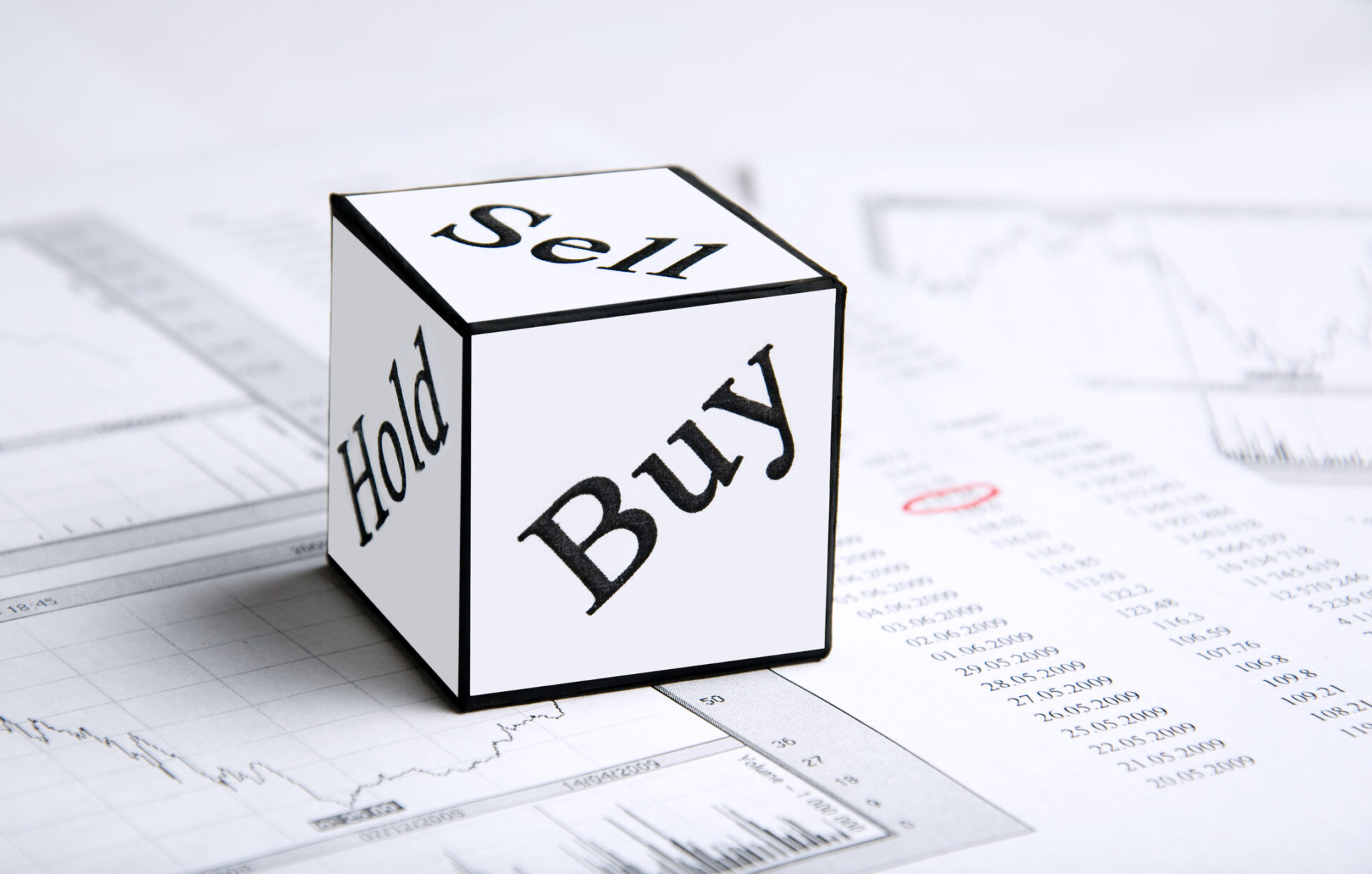 A cube or die with the words Buy, Sell, Hold.