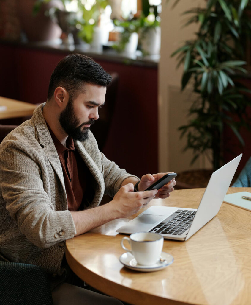 Man reading his phone in coffee shop.